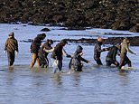 Exhausted migrants wade to shore and collapse on Dover beach