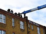 Bailiffs use cherry picker to remove squatters from former police station roof in Clapham